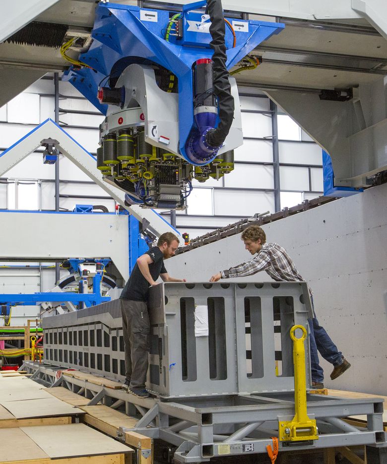 Control engineers Brad Davis, left, and Kyle Walker check the placement of carbon fiber by the machine that is making test wing spars for the Boeing 777X. The machine will alert operators of a missing or misaligned carbon-fiber strip. (Mike Siegel/The Seattle Times)