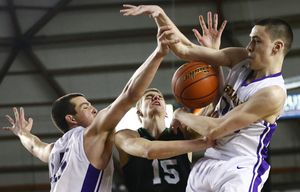 Kentwood’s Beau Roggenbach, center, draws a foul off of Issaquah defense, including Dominic Postle, left and Ethan Hammond during the Hardwood Classic quarterfinals at the Tacoma Dome on Thursday, March 3, 2016. The Hardwood Classic continues through Saturday. Kentwood pulled ahead at the end to win a close game against Issaquah, 57-51.