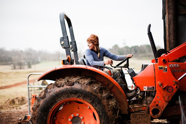 Suzanne Nelson backs a tractor out of the barn at her farm, Haw River Ranch, in Saxapahaw, N.C. (Audra Mulkern)
