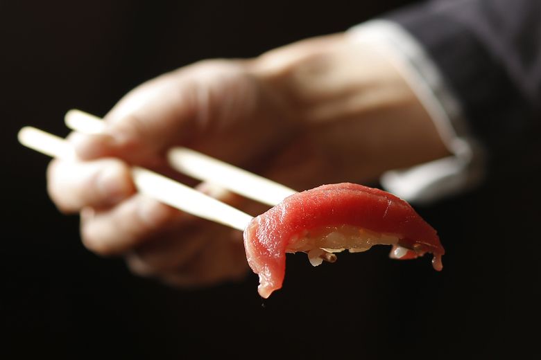 Akami, or lean tuna, brushed with nikiri, or a house blend of soy sauce, mirin and sake, on top of wasabi and rice, at Sushi Kashiba, near Pike Place Market in Seattle. (Sy Bean/The Seattle Times)