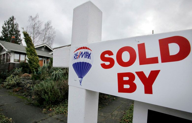 A sign promotes a newly-sold home Tuesday, Jan. 25, 2011, in Seattle. Home prices are falling across most of America’s largest cities, and average prices in eight major markets have hit their lowest point since the housing bust. The Standard & Poor’s/Case-Shiller 20-city home price index released Tuesday fell 1 percent in November from October. Eight cities, including Seattle, sank to their lowest levels since prices peaked in 2006 and 2007. (AP Photo/Elaine Thompson)