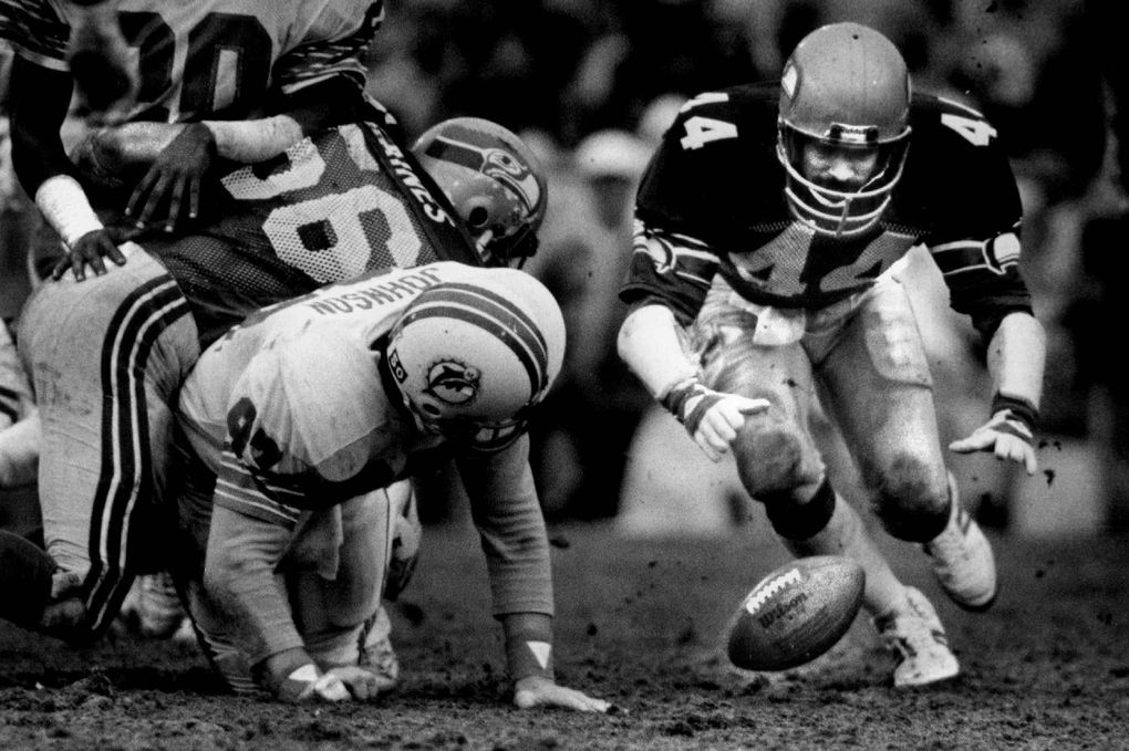 Seahawks free safety John Harris, right, fails on a fumble by Miami’s David Overstree during their AFC Divisional playoff game Dec. 31, 1983, in Miami. Seattle won 27-70 to advance to the conference championship game. (Harley Soltes / The Seattle Times)