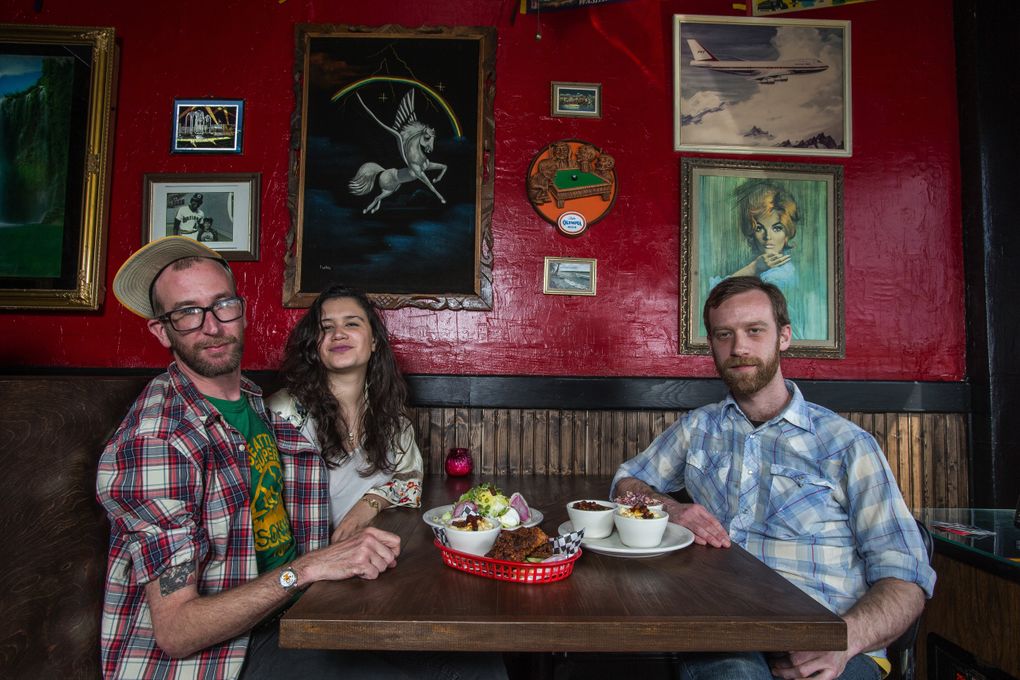 Owner Jake Manny (left) and Olivia Hall with chef Chris Barton at Sisters and Brothers. The place’s other chef is Chris Howell (they’re “a team of Chrises,” Manny says). (Dean Rutz/The Seattle Times)