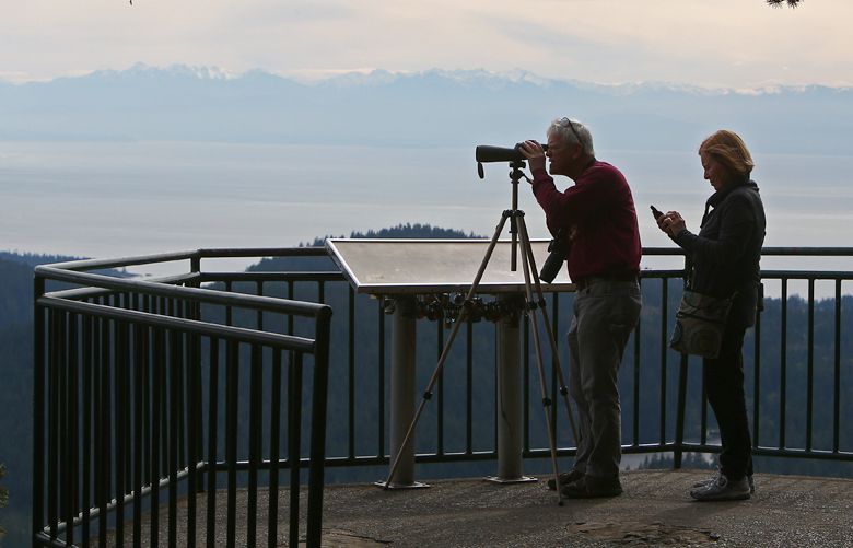 Ferndale residents, Tom and Sue Brand, use a spotting scope to look down to the 1000 Trails Campsite where their trailer is parked from a lookout on top of Mount Eerie, Sunday, April 3, 2016, in Anacortes, Wash. The couple spent the weekend in the area, visiting the tulip fields and exploring Anacortes.