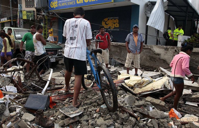 People walk among the debris of a collapsed building on April 17, 2016 after an earthquake hit the northern coastal region of Ecuador. President Correa calls a national emergency after more than 230 were killed and over 1,000 injured in the 7.8-magnitude quake. (Jose Jacome/EFE/Zuma Press/TNS)  1183531
