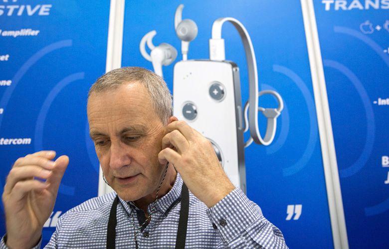 Alexander Goldin, the founder of Alango Technologies, demonstrates his Smart Assistive Listening Transceiver at the Audiology Now! convention in Phoenix, April 14, 2016. The consumer electronics industry is encroaching on the hearing aid business, offering products that are far less expensive and available without the involvement of audiologists. (David Jolkovski/The New York Times)