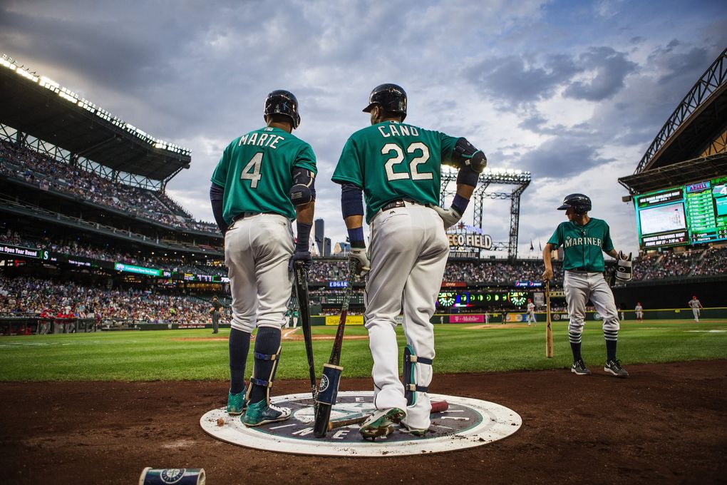 Ketel Marte and Robinson Cano talk in the warmup circle before their at-bats against the Angels on May 13 at Safeco Field. (Dean Rutz / The Seattle Times)