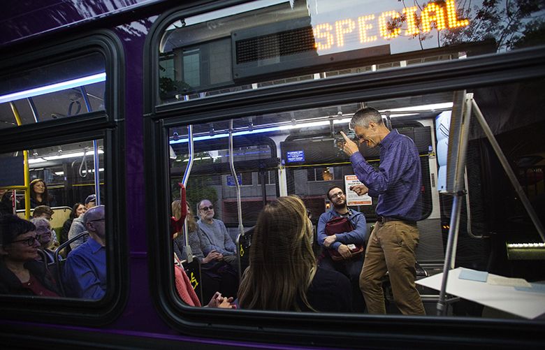 Artist Stokley Towles wags his finger while telling a story as he performs “Behind the Wheel: Life on the Metro Bus” on a King County Metro bus marked “Special” and stopped at the Route 47 bus stop next to the Lookout bar on Capitol Hill, Thursday, April 28, 2016. In the roughly 50-minute, one-man performance piece, Towles shares stories gathered from his interviews of over 30 Metro bus drivers about their experiences on the job.
Each vignette begins with Towles reading a quote from a driver he’s interviewed. One reads: “You gotta be a teacher, a psychiatrist, a doctor, a lawyer, a parent, the whole nine yards, and this all in one tripÉ” Towles says he tries to explore how drivers take on those different roles. “How do they mentally survive the work?”
One of Towles’s audience members Thursday was Metro driver Jeannetta Moreland, who got to take in the performance while she kept an eye on the bus. “Most people don’t notice the driver,” said Moreland, who says she knows all of the drivers Towles interviewed. “I never looked at my life the way he just did. It was all on point. ”
For information on upcoming performances visit: www.stokleytowles.com