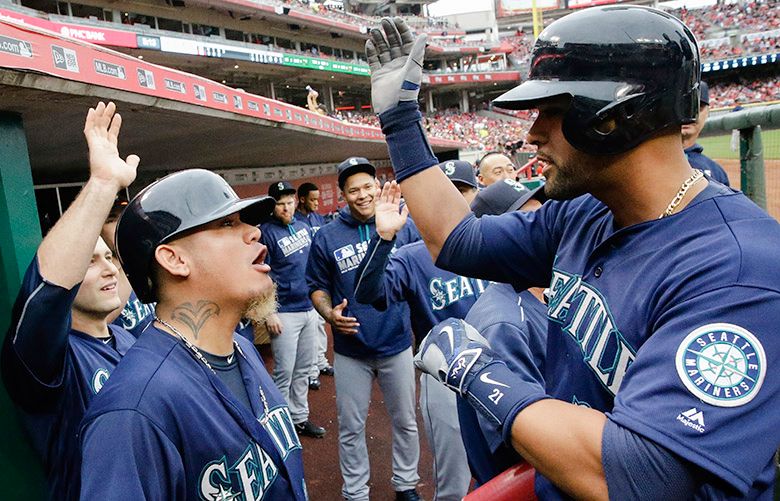 Seattle Mariners' Franklin Gutierrez runs the bases after hitting a  three-run home run off Cincinnati Reds starting pitcher John Lamb, right,  in the fourth inning of a baseball game, Saturday, May 21