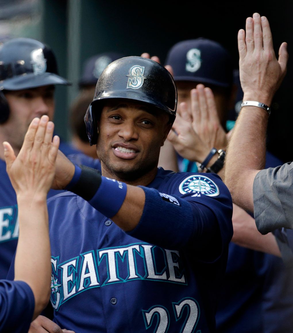 Mariners’ Robinson Cano high-fives teammates in the dugout after scoring on a single by Nelson Cruz on May 17 in Baltimore. (Patrick Semansky / AP)