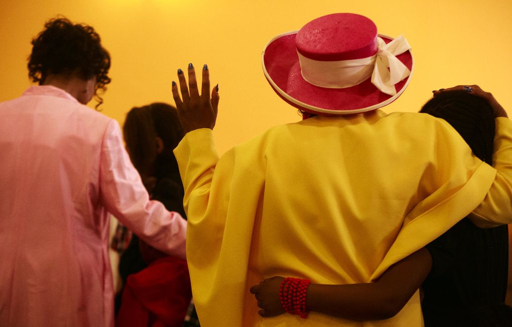 Tracey Freeman, in yellow, worships at Truevine of Holiness Missionary Baptist Church. Many churches fill the storefronts of the Skyway business district. (Erika Schultz/The Seattle Times)