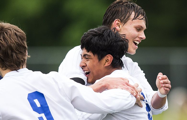 Cris Garfias-Jolley is greeted by teammates Charlie Wilcox, back right, and Cameron Jolley, left, after scoring a goal in the first half during a 4A quarterfinal game at Tahoma High School in Covington on Saturday, May 21, 2016. Tahoma shut out Mariner 2-0 to advance to the semifinals.