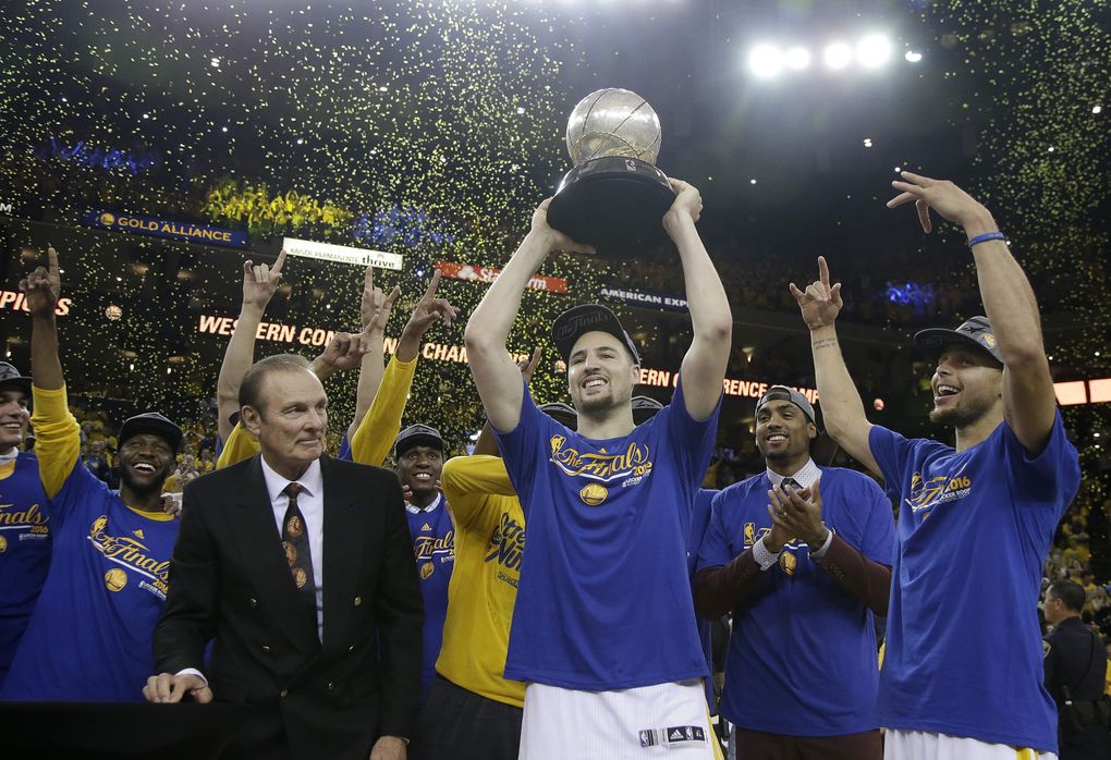 Former NBA player Rick Barry (in suit) watches as Golden State Warriors guard Klay Thompson (center) Steph Curry (right) and their teammates celebrate after beating the Oklahoma City Thunder in Game 7 of the NBA Western Conference finals. (Macio Sanchez /AP)