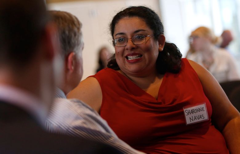 Sharonne Navas, executive director of the Equity in Education Coalition of Washington, speaks with other discussion participants during the Education Lab event on school funding at Pacific Tower in Seattle, Wednesday, June 1, 2016.