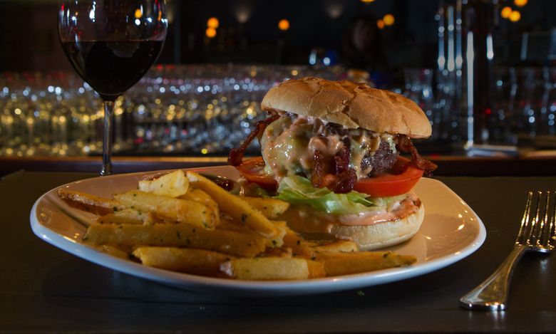 El Gaucho’s 410 Burger features a ½-pound patty of Niman Ranch Angus beef topped with English Coastal cheddar, bacon and Thousand Island dressing served on a brioche bun. It’s served with duck-fat fries, and it’s as big, rich and classic as the steakhouse itself.  (Ellen M. Banner/The Seattle Times)
