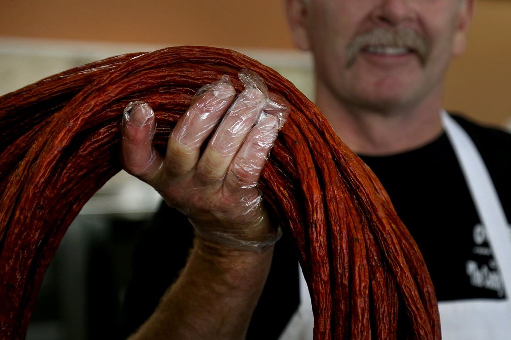 Don Owens holds up a batch of mild pepperoni, sold by the yard at Owens Meats, a popular stop for locals and visitors alike in Cle Elum. (Johnny Andrews/The Seattle Times)