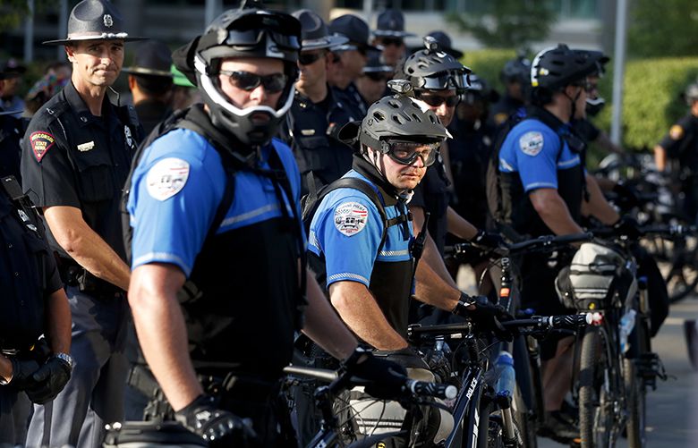 Police officers stand in formation near demonstrators Tuesday, July 19, 2016, in Cleveland, during the second day of the Republican convention. (AP Photo/John Minchillo) RNC754