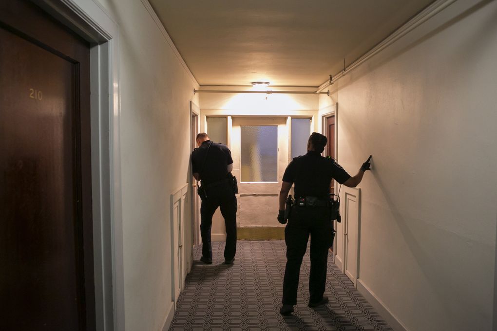 Officers Jameson Mahler, left, and Melisande Manning do a welfare check on a woman in an apartment on Capitol Hill. The woman’s mother had called the police to ask them to check on her, but she never came to the door. (Bettina Hansen/The Seattle Times)