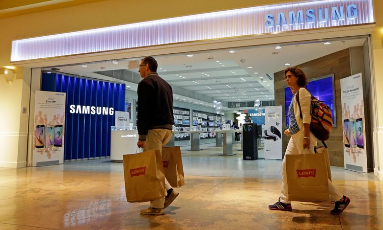 In this photo taken Tuesday, Feb. 9, 2016, shoppers walk by a Samsung store in Miami. On Friday, July 15, 2016, the Commerce Department releases U.S. retail sales data for June. (AP Photo/Alan Diaz)