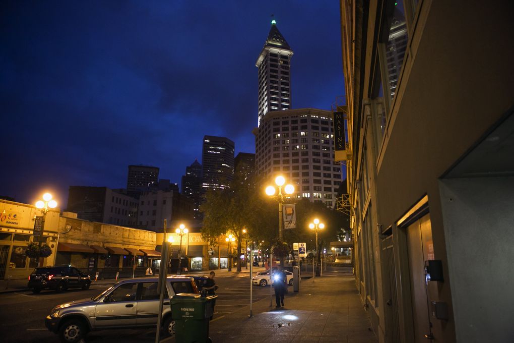 Officers Melisande Manning and Chris Couet assist an investigation for the West Precinct in Pioneer Square, looking for broken glass and blood spatter after a brawl. (Bettina Hansen/The Seattle Times)