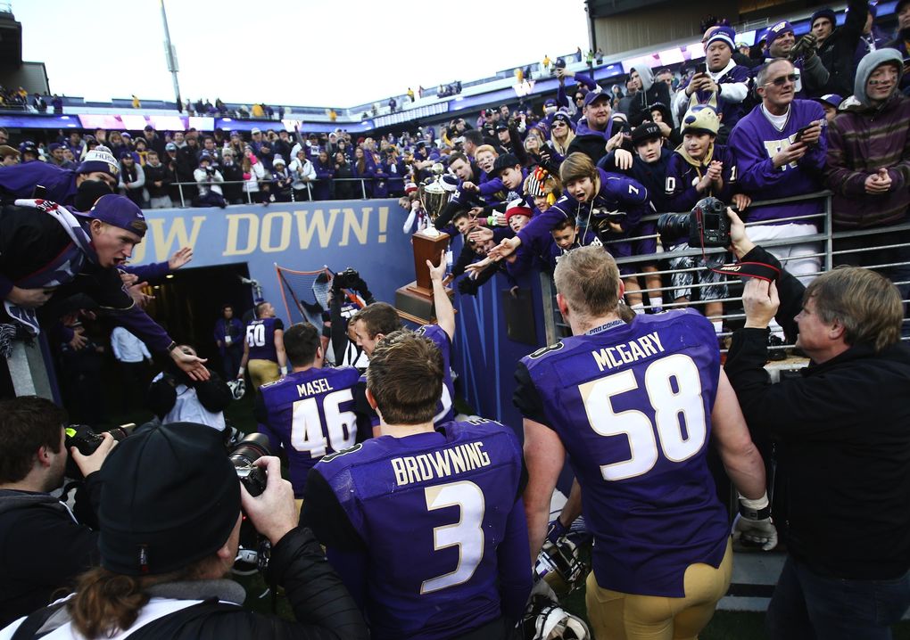 Washington quarterback Jake Browning (3) walks off the field with Washington offensive lineman Kaleb McGary as fans cheer while they try to touch the Apple Cup trophy during the 108th Apple Cup at Husky Stadium on Friday, Nov. 27, 2015. Washington beat Washington State 45-10. (Lindsey Wasson / The Seattle Times)