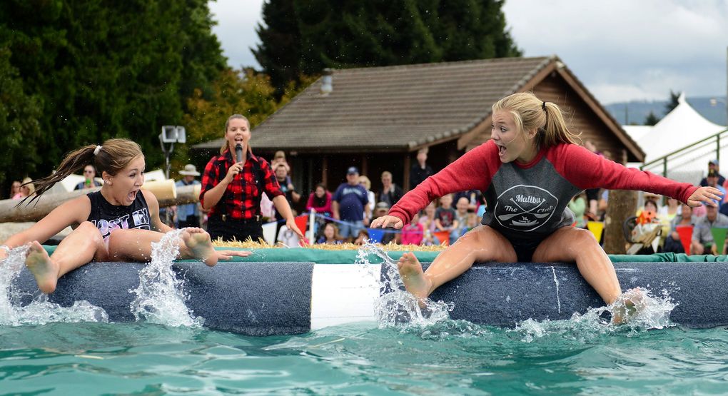 Sydney Todd and Synnova Eide scream as they fall backwards off a log during the International Lumberjack Show at the Evergreen State Fair. (Lindsey Wasson / The Seattle Times)
