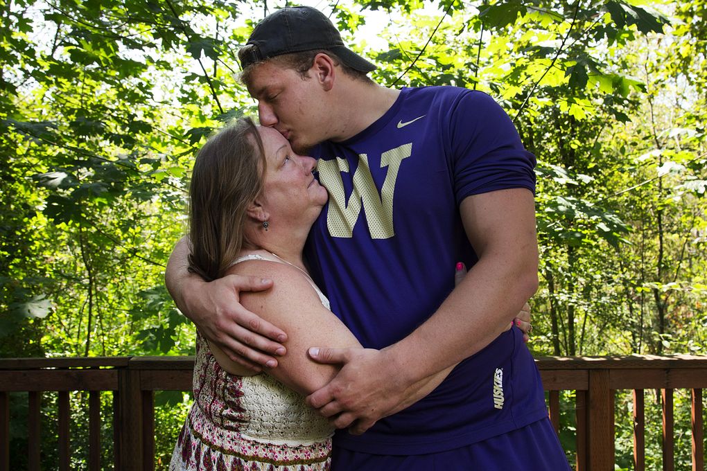 University of Washington offensive lineman Kaleb McGary kisses his mother, Cassandra McGary, on the forehead on the Hylebos Wildlife Trail in Fife earlier this month. (Johnny Andrews/The Seattle Times)