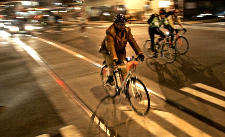 A cyclist coasts between the rails of the new South Lake Union streetcar in 2007. (John Lok / The Seattle Times)
