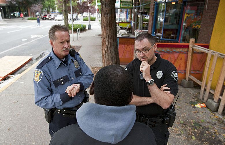 101211 – SEATTLE, WA – Victor Maes, left, of the Seattle Police Department, and Brooks Raymond, right, of the Department of Corrections, speak with a regular on the streets of Belltown about services that might be helpful to him. Local law enforcement, long frustrated with the status quo of arrest, prosecution and incarceration for drug offenders or prostitutes, are trying a new approach. Called LEAD – Law Enforcement Assisted Diversion – the program give officers the discretion to take someone to jail or bypass the criminal justice system if there’s a chance that individuals would take advantage of a program to change their lives through employment and housing assistance, educational opportunities and other services.