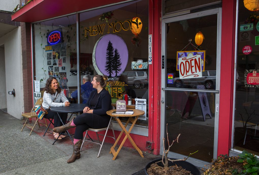 Brandi Hughes, left, and Jenny Slocum wait for a table at the New Moon Cooperative Cafe in Olympia. The cafe is owned and managed by its workers. (Ellen M. Banner/The Seattle Times)