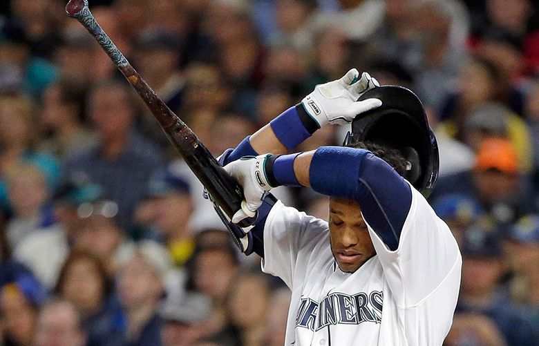Seattle Mariners’ Robinson Cano takes a break to wipe his brow while batting against the Houston Astros during the first inning of a baseball game Friday, Sept. 16, 2016, in Seattle. (AP Photo/Elaine Thompson) WAET107