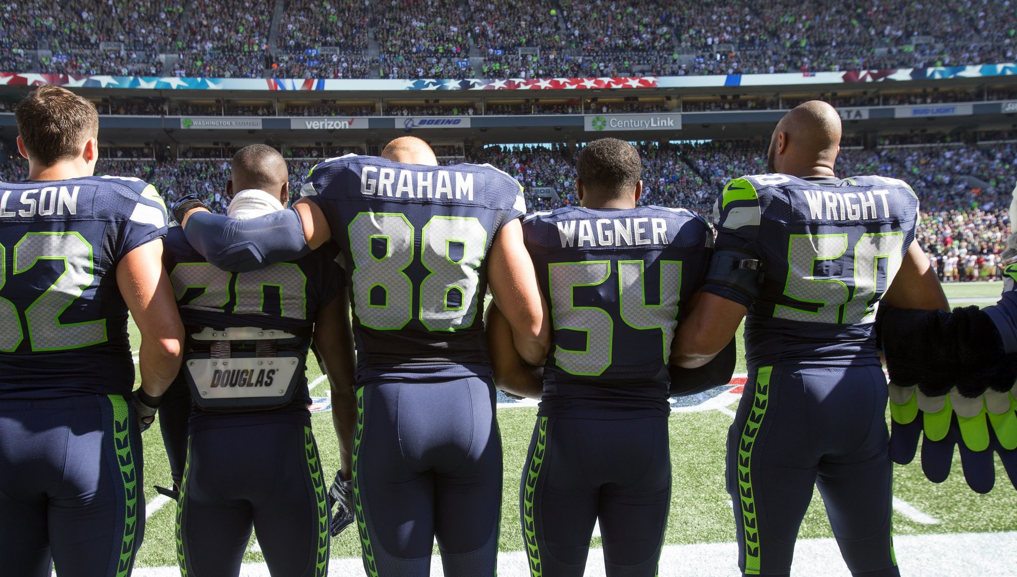 49ers' Colin Kaepernick kneels, Seahawks stand arm-in-arm during