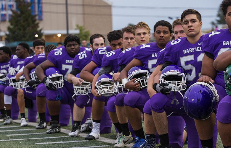 Landover, United States. 25th Oct, 2020. Members of the Washington Football  Team stand, kneel, and hold their first up during the national anthem  before an NFL football game against the Dallas Cowboys