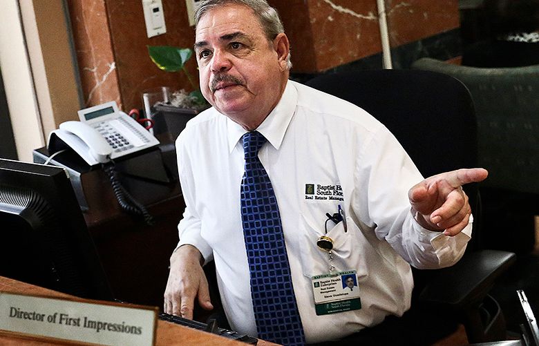 Steve Guadalupe, now 68, shifted from maintenance work at the Baptist Hospital of Miami to running the concierge desk. (Scott McIntyre / The New York Times)