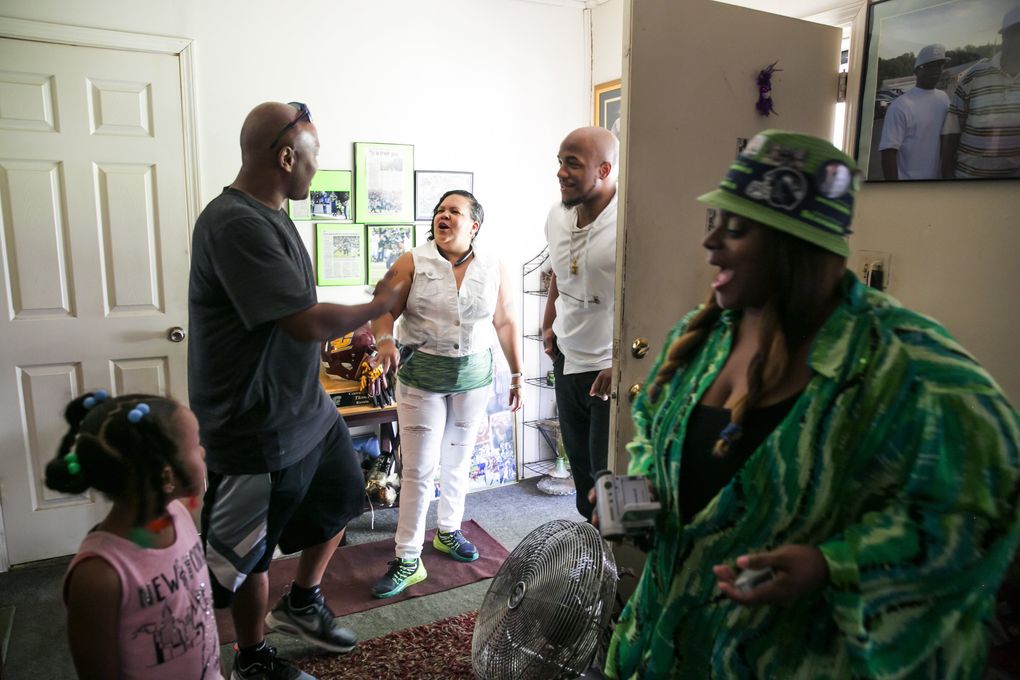 Family and friends meet in the house where the Rawls family grew up, from left, Al Washington and his daughter Alyssa, 6, Veronica “Aunt Tweety” Thompson, Thomas “Rell” Rawls and Deadra Whitley. Washington coached “Ty,” Thomas Rawls of the Seahawks, while he was a kid in Flint Youth Football, and Aunt Tweety was the one who encouraged the boys to join in the first place. The house belonged to “Granny,” or Diane Rawls, Thomas “Terrell” Rawls’ mother, and Whitley lived next door, so their three kids could go between the two houses. (Bettina Hansen/The Seattle Times)
