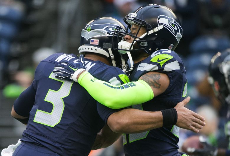 Seattle Seahawks quarterback Russell Wilson, right greets a former