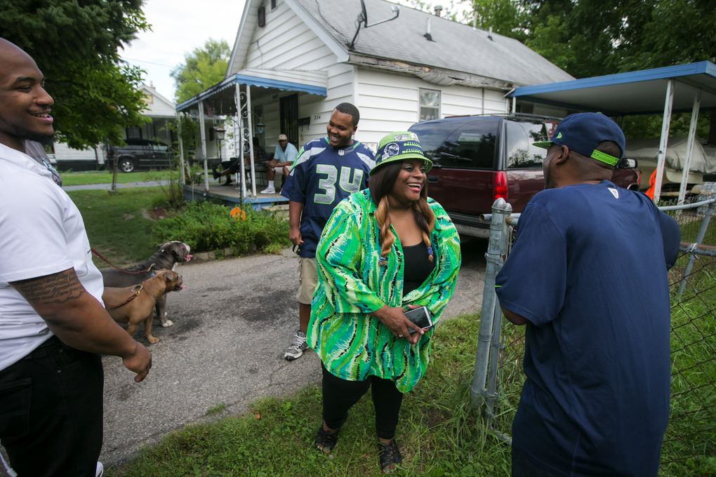 Deadra Whitley talks to Derrin “Uncle Duke” Rawls outside Granny’s house on Foss Ave. in the north end of Flint, Mich. Her middle son Thomas “Rell” Rawls is to the left, and his cousin Quientin Lee is behind her. Diane Rawls, known as Granny, owned the house for decades until she died earlier this year. Deadra’s kids grew up in Granny’s house with their father and she lived in the house next door. (Bettina Hansen/The Seattle Times)