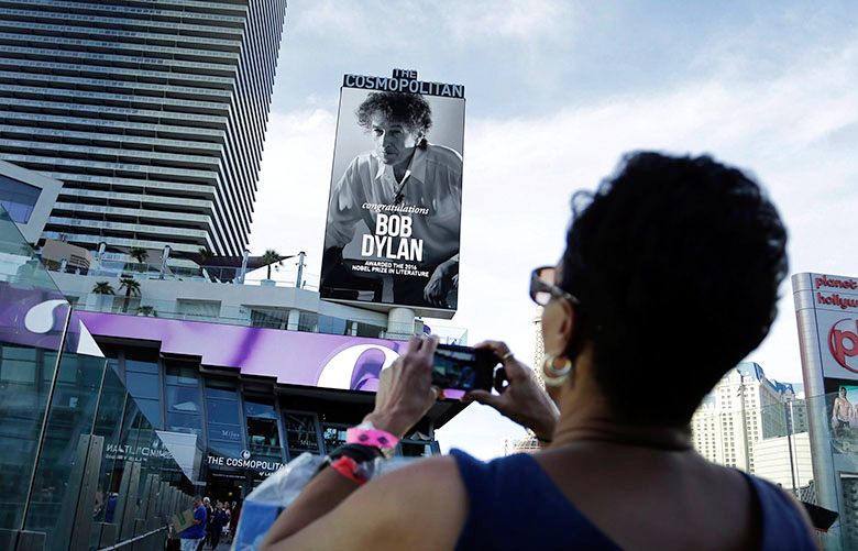 epa05584517 US singer Bob Dylan’s name and picture appears on a marquee complete with congratulations on his being awarded the Nobel Prize for Literature outside the Cosmopolitan of Las Vegas Hotel in Las Vegas, Nevada, USA, 13 October 2016. Dylan is scheduled to perform at the hotel, on the day he was awarded the Nobel Prize in Literature ‘for having created new poetic expressions within the great American song tradition’.  EPA/PAUL BUCK