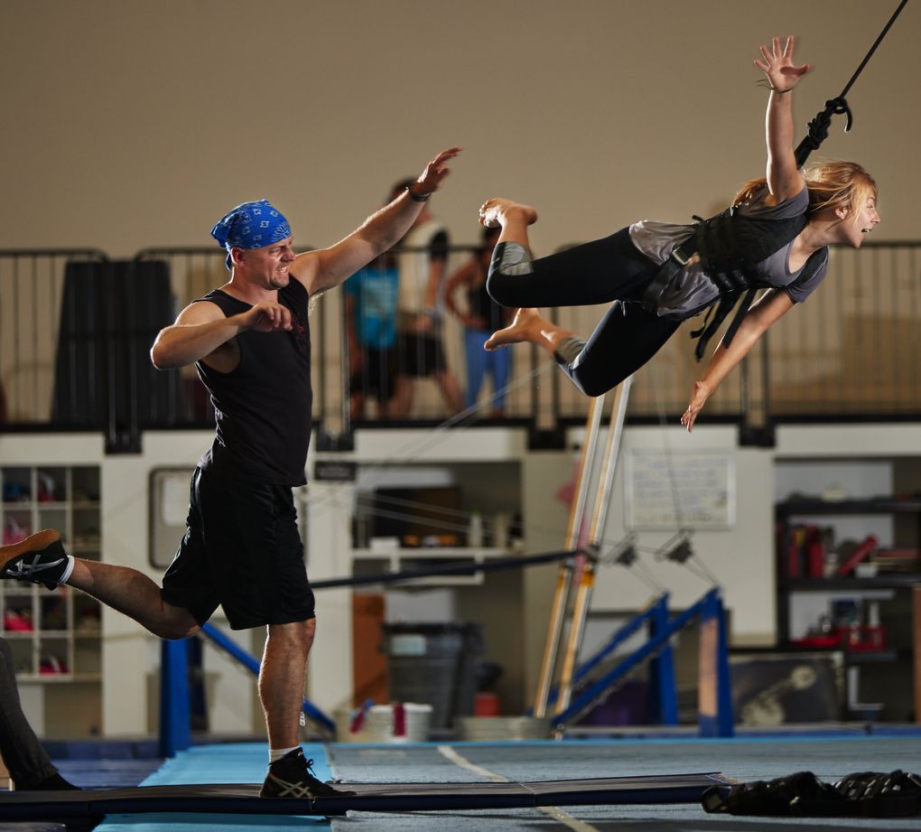 Instructor Greg Poljacik, left, launches student Kyla Hymas, who flies through the air with the help of a ratchet system. (Benjamin Benschneider/The Seattle Times)