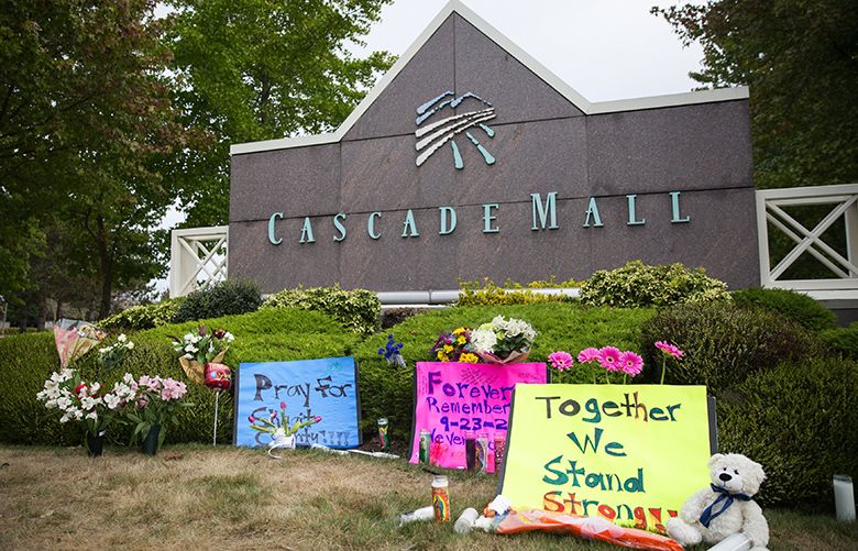 A small memorial of signs, flowers and candles for the shooting victims sits outside an entrance to Cascade Mall in Burlington on Sunday, Sept. 25, 2016. On Friday night, Arcan Cetin entered the Macy’s at Cascade Mall in Burlington and fatally shot five people with a rifle near the cosmetics section. Cetin was arrested by police Saturday evening.