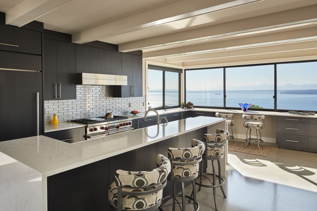 The kitchen island’s waterfall design “puts the work space down a level,” Rhonda Nelsen says. Two upper cupboards back out of the way of the view, and a drawer microwave frees up counterspace. (Benjamin Benschneider/The Seattle Times)