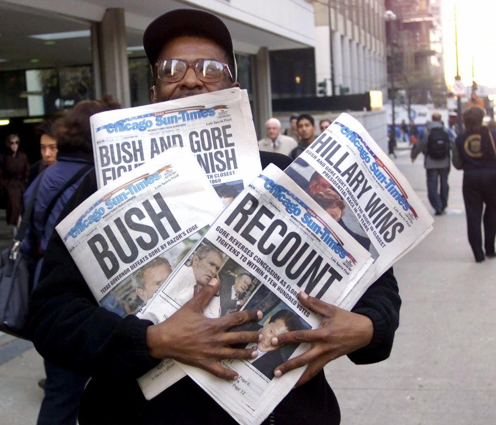 Willie Smith holds four copies of the Chicago Sun-Times, each with a different headline, reflecting the suspense of the Bush-Gore presidential race in 2000. (Charles Bennett / The Associated Press, file)