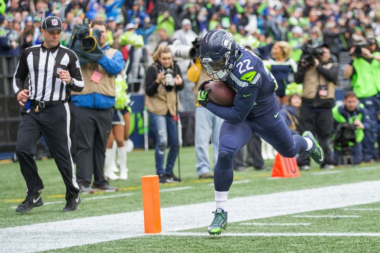 A Seattle Seahawks fan wearing a Russell Wilson jersey waves a