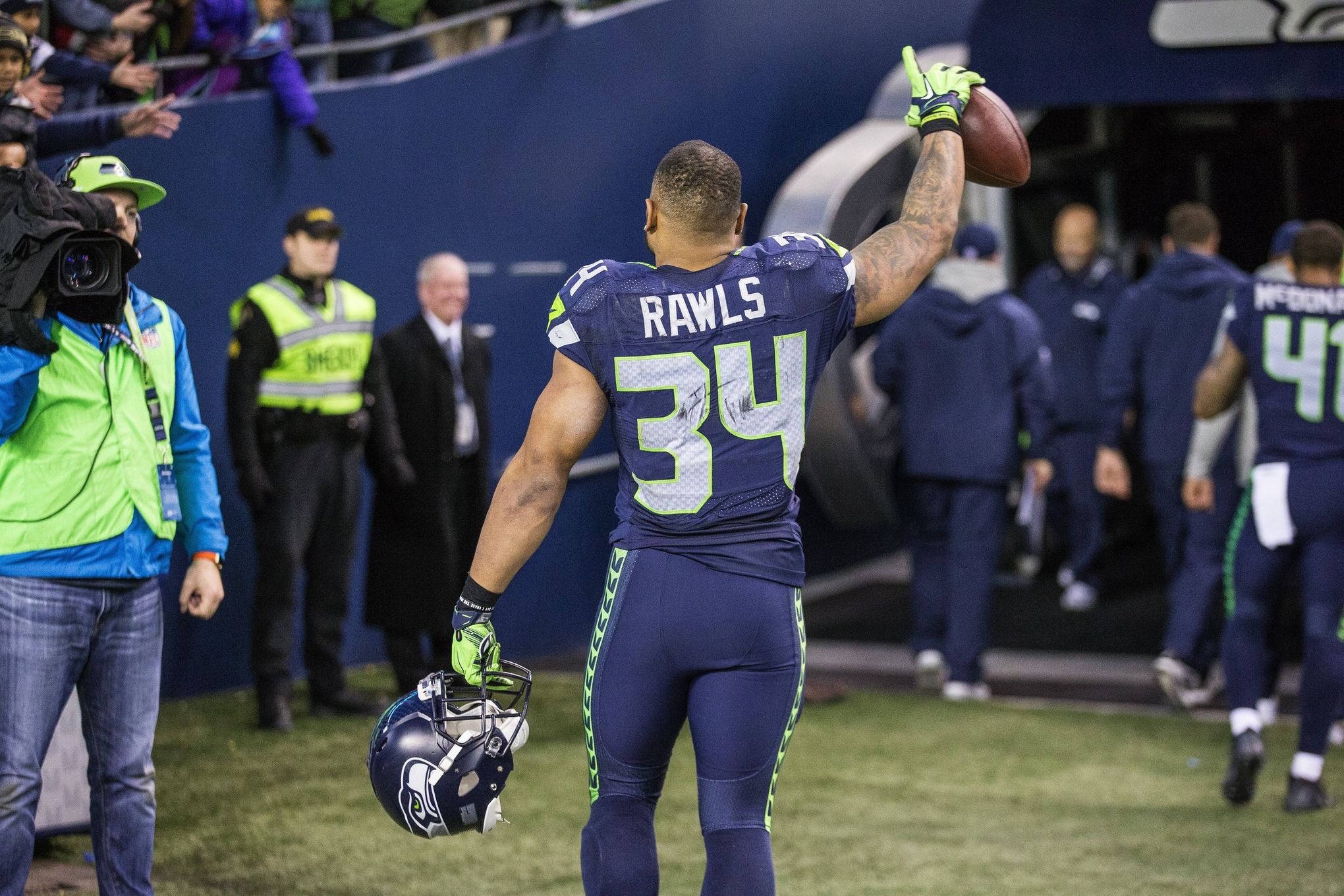 A Seattle Seahawks fan wearing a Russell Wilson jersey waves a