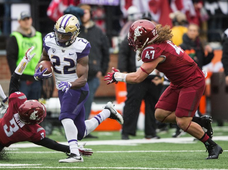 Washington running back Lavon Coleman (22) skirts a tackle from Washington State cornerback Darrien Molton (3) and Washington State linebacker Peyton Pelluer (47) on his way to score a 22 yard touchdown in the second quarter for the 109th Apple Cup at Martin Stadium in Pullman, Wash. on Friday, Nov. 25, 2016.   (Lindsey Wasson / The Seattle Times)