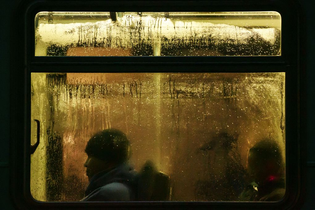 Commuters travel by bus on Third Avenue during a stormy evening in downtown Seattle. (Erika Schultz/The Seattle Times)