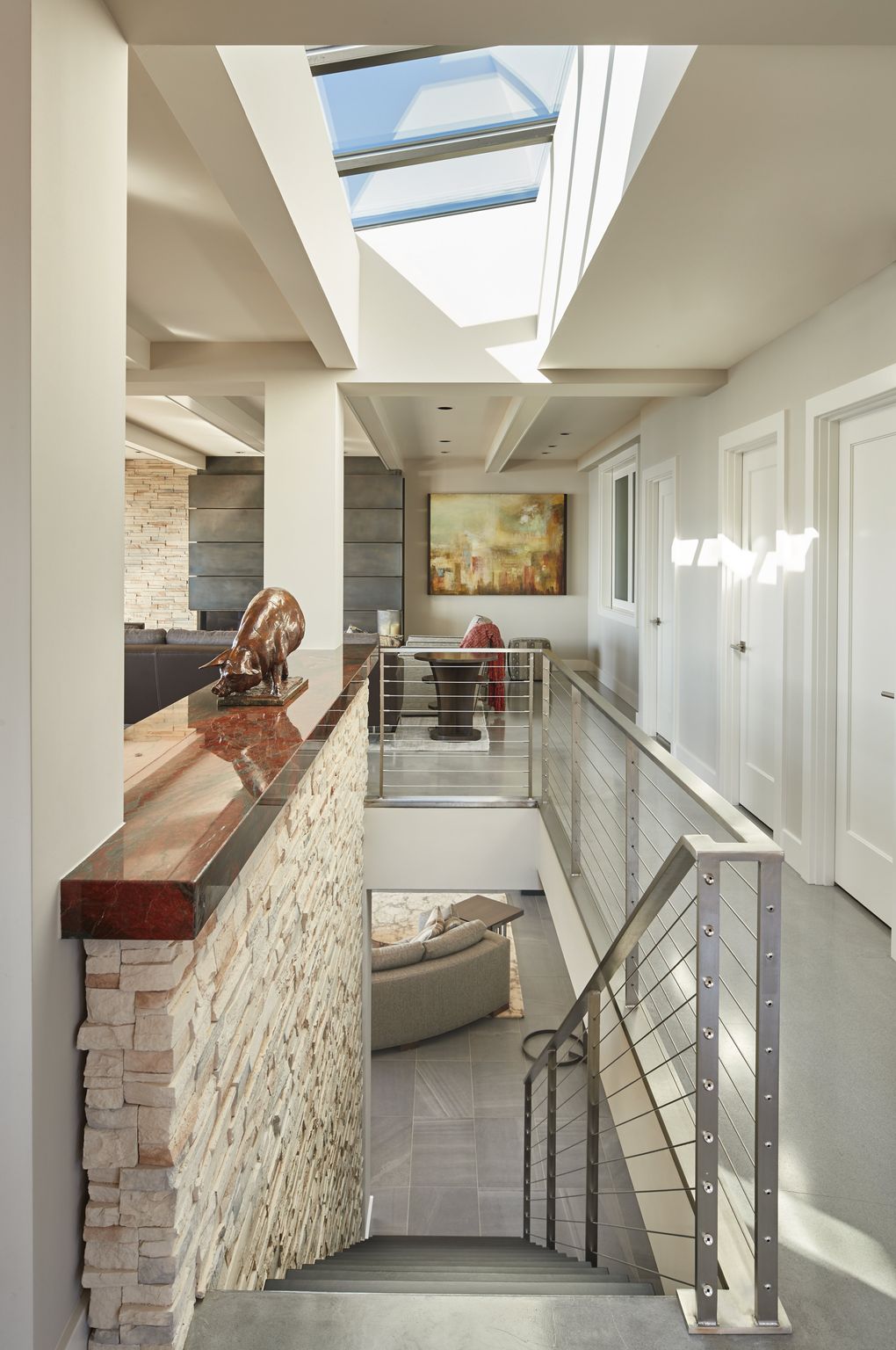 “It was a process picking the slab at the top of the stairs,” says Adin Houck, of Rainier Custom Homes. “I love that granite — Red Hollywood — when you come in, it catches the eye,” homeowner Rhonda Nelsen says. Bella the pig was a gift from her husband, Larry. (Benjamin Benschneider/The Seattle Times)