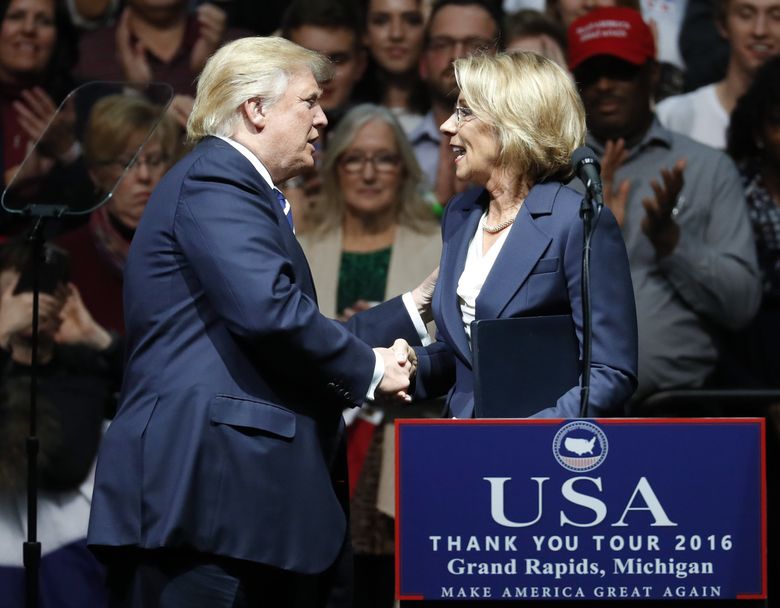 President-elect Donald Trump shakes hands with his pick for Education Secretary Betsy DeVos during a rally, in Grand Rapids, Mich., Friday, Dec. 9, 2016. (AP Photo/Paul Sancya) MIPS103