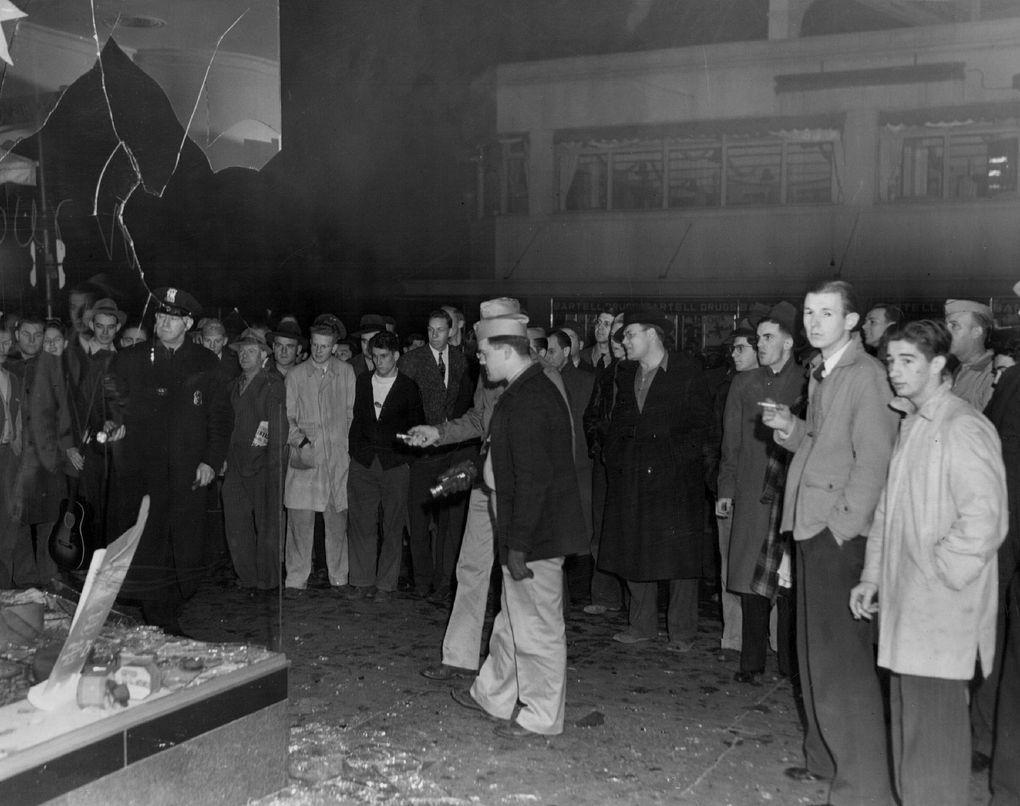 Tin cans and bottles flew in Seattle streets as a crowd estimated at 2,000 vented anger at store lights left on during the blackout. This photograph shows a broken window at Fourth Avenue and Pine Street.