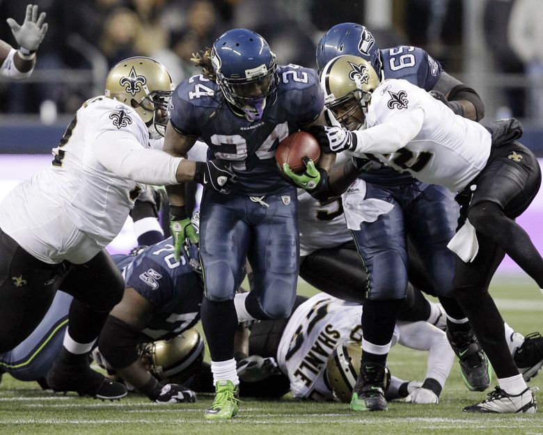 Seahawks’ Marshawn Lynch (24) breaks away from a tackle by the New Orleans Saints defenders to score a touchdown in the second half of an NFL NFC wild card playoff football game, Saturday, Jan. 8, 2011, in Seattle a run later remember as the “beast Quake” run.  (Elaine Thompson / The Associated Press)